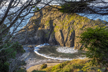 Waves surging through a hole in Arch Rock create an interesting arcing wave, Harris Beach State Park, near Brookings;  Oregon, United States of America