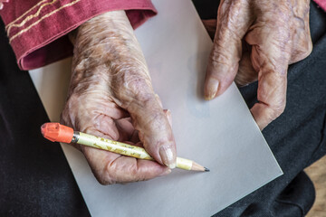 Senior woman's hands getting ready to write a note with a pencil; Olympia, Washington, United States of America