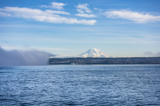 Mount Rainier looming behind the town of Steilacoom, Washington, with a fog bank encroaching from the left; Steilacoom, Washington, United States of America