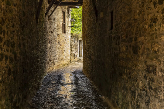 Narrow pathway between stone walls of buildings; Santillana del Mar, Cantabria, Spain
