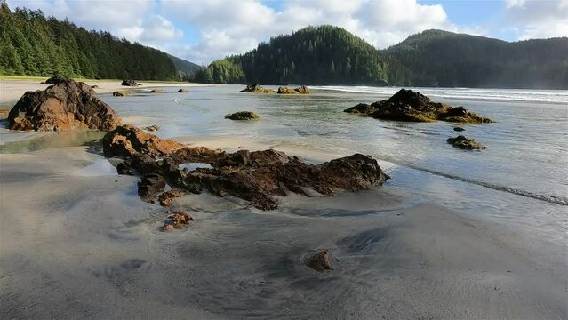 Sandy beach on Pacific Ocean Coast View. Sunny Blue Sky. San Josef Bay, Cape Scott Provincial Park, Northern Vancouver Island, BC, Canada. Canadian Nature Background. Cinematic 4k Slow Motion