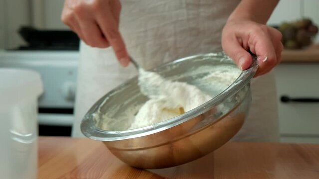 cook mixes cottage cheese with egg and sugar. the chef prepares the dough. chef preparing cheesecake. hands stir the dough in an iron plate
