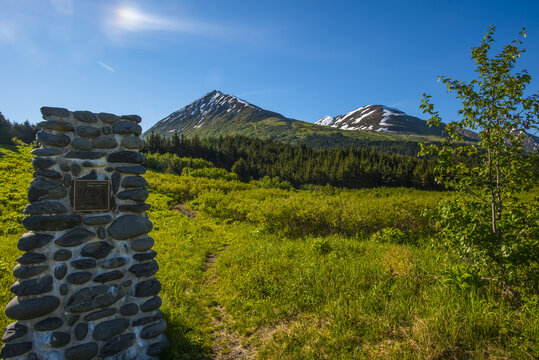A stone monument marks the start of the Nissman Center Ridge Trail Head near Turnagain Pass Alaska on a sunny summer morning; Alaska, United States of America