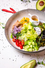 salad with tuna, olives and other ingredients on a white plate