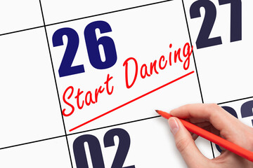 26th day of the month. Hand writing text START DANCING and drawing a line on calendar date.