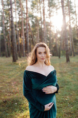 Obraz premium Pregnant happy young woman walking outdoors in forest