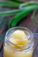 Macro royal jelly in the spoon above the pot