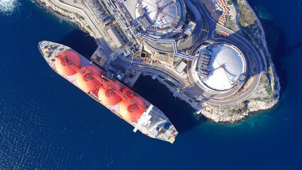 Aerial drone top down photo of LNG (Liquified Natural Gas) tanker anchored in small gas terminal...