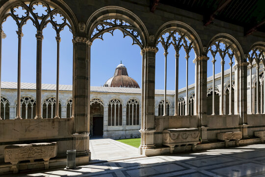 View of the Baptistry through the arches of Camposanto Monumentale (Campo Santo, Monumental Cemetery); Pisa, Italy