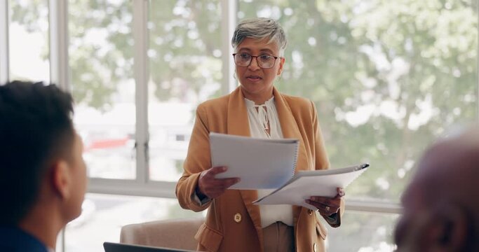 Meeting, discussion and woman review documents, analytics report and business proposal in office. Teamwork, leadership and senior female ceo with paperwork for planning, marketing strategy and ideas