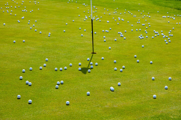 Numerous golf balls by a hole on golf course, creating chaos; Lucerne, Lucerne, Switzerland