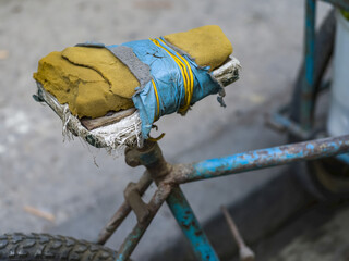 Bicycle seat in disrepair, patched with tape over worn foam on a very old bicycle; Havana, Cuba