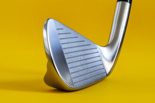 Wedge golf club on a bright yellow background