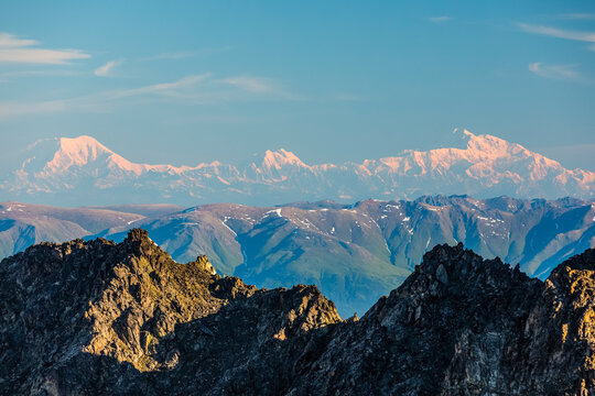 Distant view of Mount Foraker (left), Mount Hunter (center), and Denali (right) overlooking the summit ridge of Pioneer Peak; Alaska, United States of America