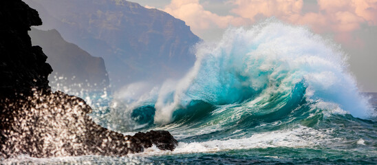 Large ocean wave crashes into rock along the Na Pali Coast; Kauai, Hawaii, United States of America