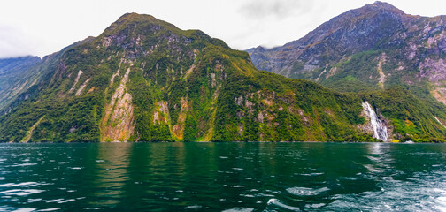 Tranquil waters along lush coastline of Milford Sound; South Island, New Zealand