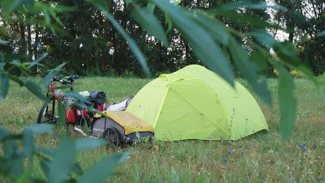 Tent, Bicycles And Camping Equipment On The Grass In A Green Meadow