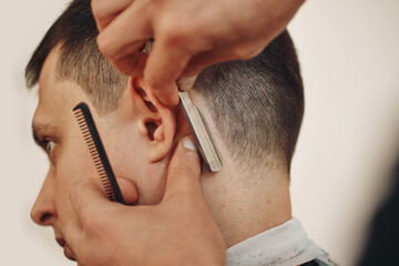 Obraz premium Barber shaving bearded man with retro knife