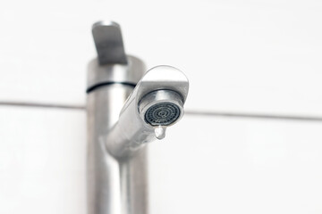 Obraz premium Water dripping from the faucet in the bathroom. Water faucet close-up. Saving water