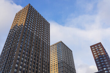 Modern high-rise brick buildings against blue sky with cloud in sunny day