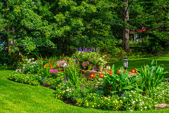 Landscaped flower garden in bloom in a yard; Hudson, Quebec, Canada
