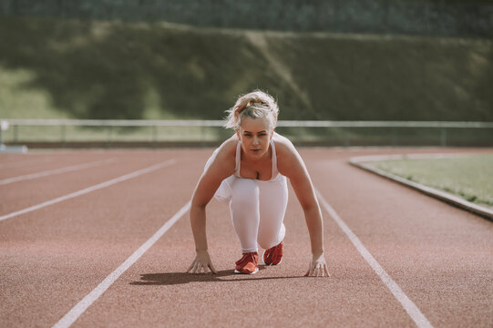 Woman in a starting position for running on a track; Wellington, New Zealand