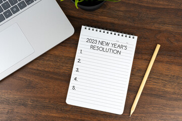 2023 New Year's resolutions text on note pad on top of office desk