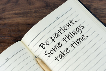 Inspirational quotes on note pad with text - Be patient, some things take time.