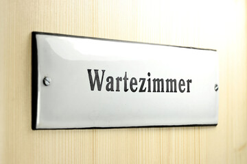 enamel sign on the door to the waiting room of a German doctor's office
