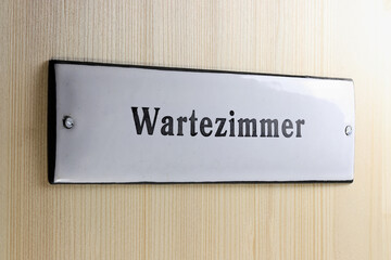 enamel sign on the door to the waiting room of a German doctor's office
