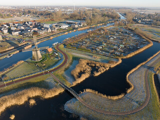Obraz premium Strijkmolen E, Ouddorp, Alkmaar, North Holland,The Netherlands. Oak octagonal polder mill from 1630. Ironing mills do not drain polders, grind the water from one reservoir to the other. Winter aerial.