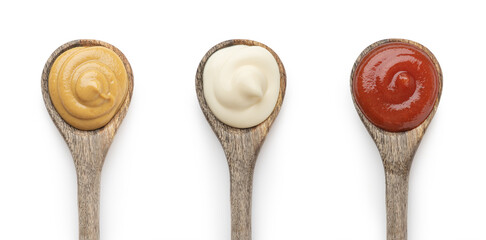 A set of sauces in wooden spoons on a white background