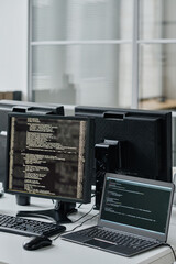 Close-up of workplace of developers with computers and laptop on table for online work