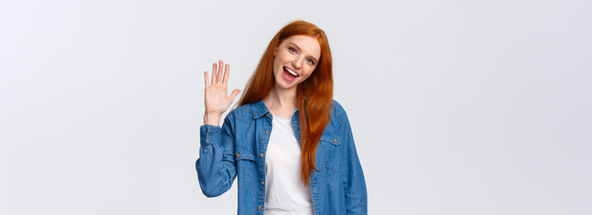 Friendly, cheerful and outgoing pretty redhead girl waving palm, saying hello, greeting team...