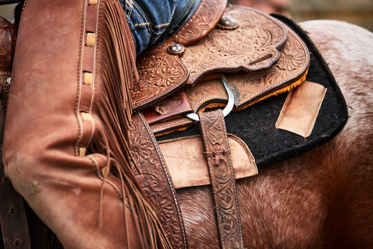 Leatherwork and closer details of a saddle and chaps to the left side; Eastend, Saskatchewan, Canada