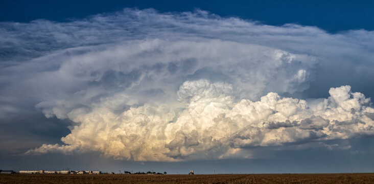 Robust updrafts begin to glow as the sun begins to set on an impressive line of increasingly severe thunderstorms; Burlington, Colorado, United States of America
