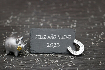 Obraz premium Cerdo de la suerte y herradura con felicitaciones para el año nuevo. Feliz Año Nuevo 2023.