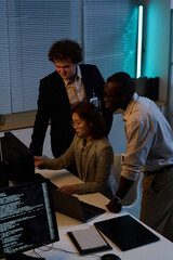 High angle view of team of programmers developing new program on computer during their work in...