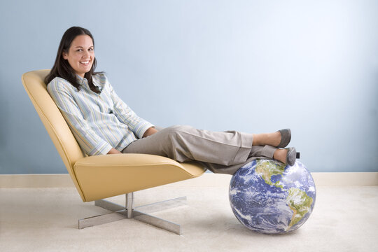 Businesswoman Sitting With Her Feet on a Globe