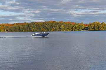 cloudy blue sky over a peaceful minnesota lake with boat
