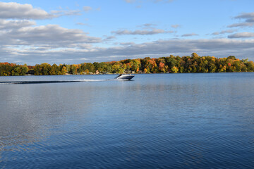 cloudy blue sky over a peaceful minnesota lake with boat