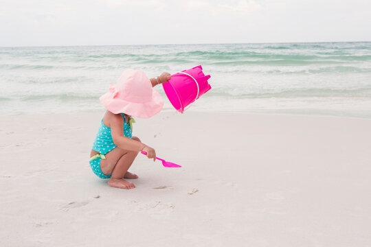 Toddler Girl Playing with Shovel and Bucket in Sand on Beach, Destin, Florida, USA