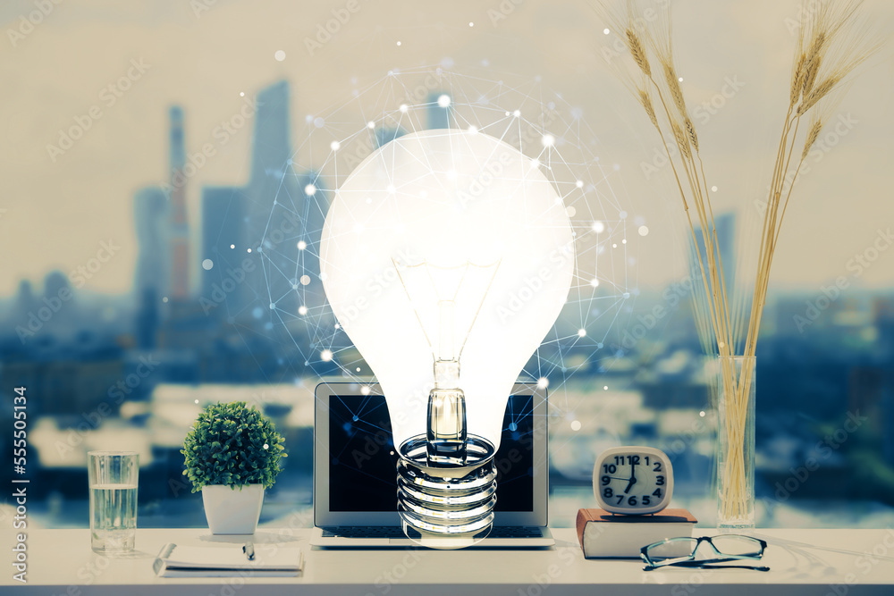 Poster Computer on desktop in office with bulb icon hologram. Double exposure. Concept of idea.