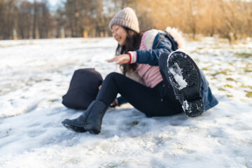 Fototapeta na wymiar woman slips and falls down on snowy road.