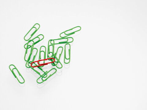 Green and red paper clips on white background, studio shot