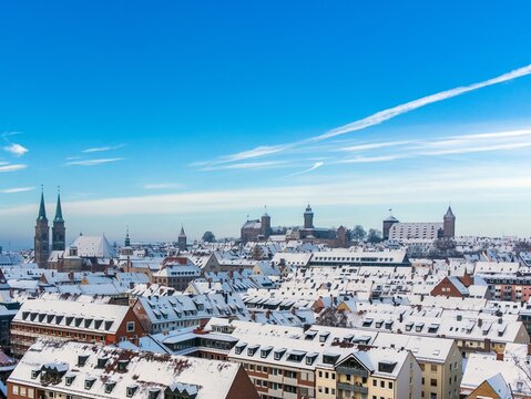 Winter panorama view over the blurred roofs of Nuremberg old town, with bright blue sky in the background. 