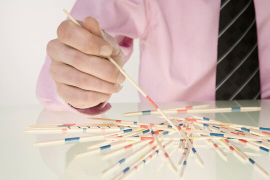 Businessman Playing Pick-Up Sticks