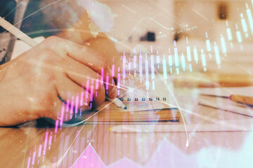 Multi exposure closeup hands with stock market forex graph.