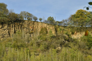 Pans rocheux verticaux &eacute;mergeant de la v&eacute;g&eacute;tation luxuriante et sauvage dominant la vall&eacute;e de l'Ambl&egrave;ve &agrave; Aywaille 
