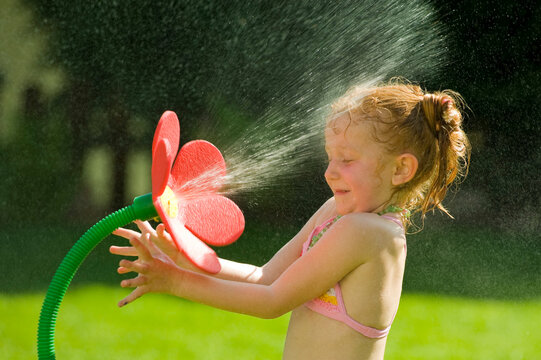 Girl Playing With Flower Sprinkler, Salzburg, Austria